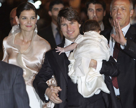 Actor Tom Cruise holds his daughter Suri as he arrives with his fiancee Katie Holmes (L) at a restaurant in Rome November 16, 2006. 